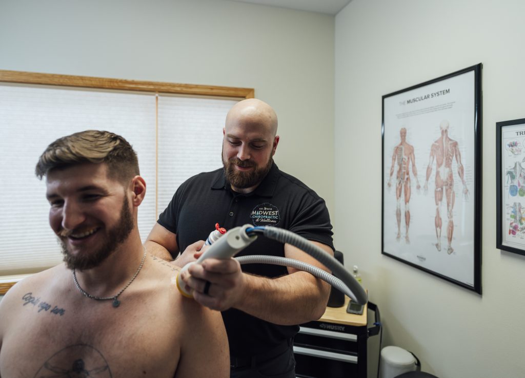 Dr. Mitch giving a SoftWave TRT treatment at Midwest Chiropractic & Wellness