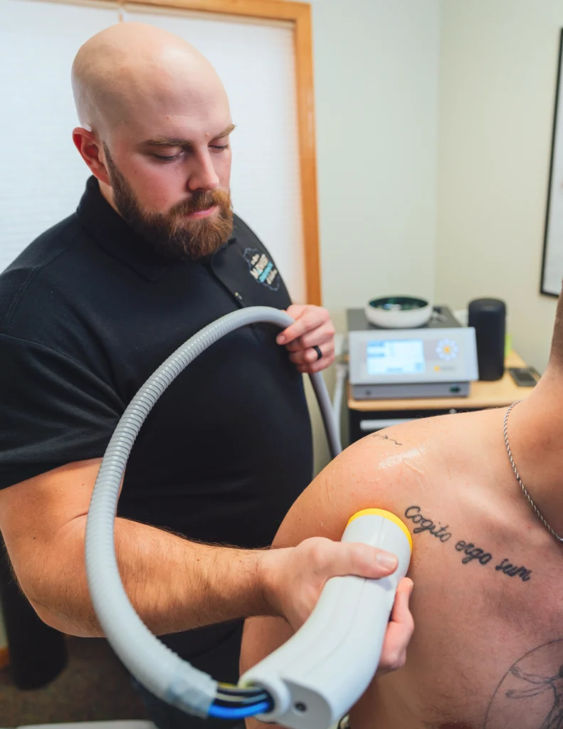 SoftWave TRT applicator in use on a patient's shoulder at Midwest Chiropractic & Wellness