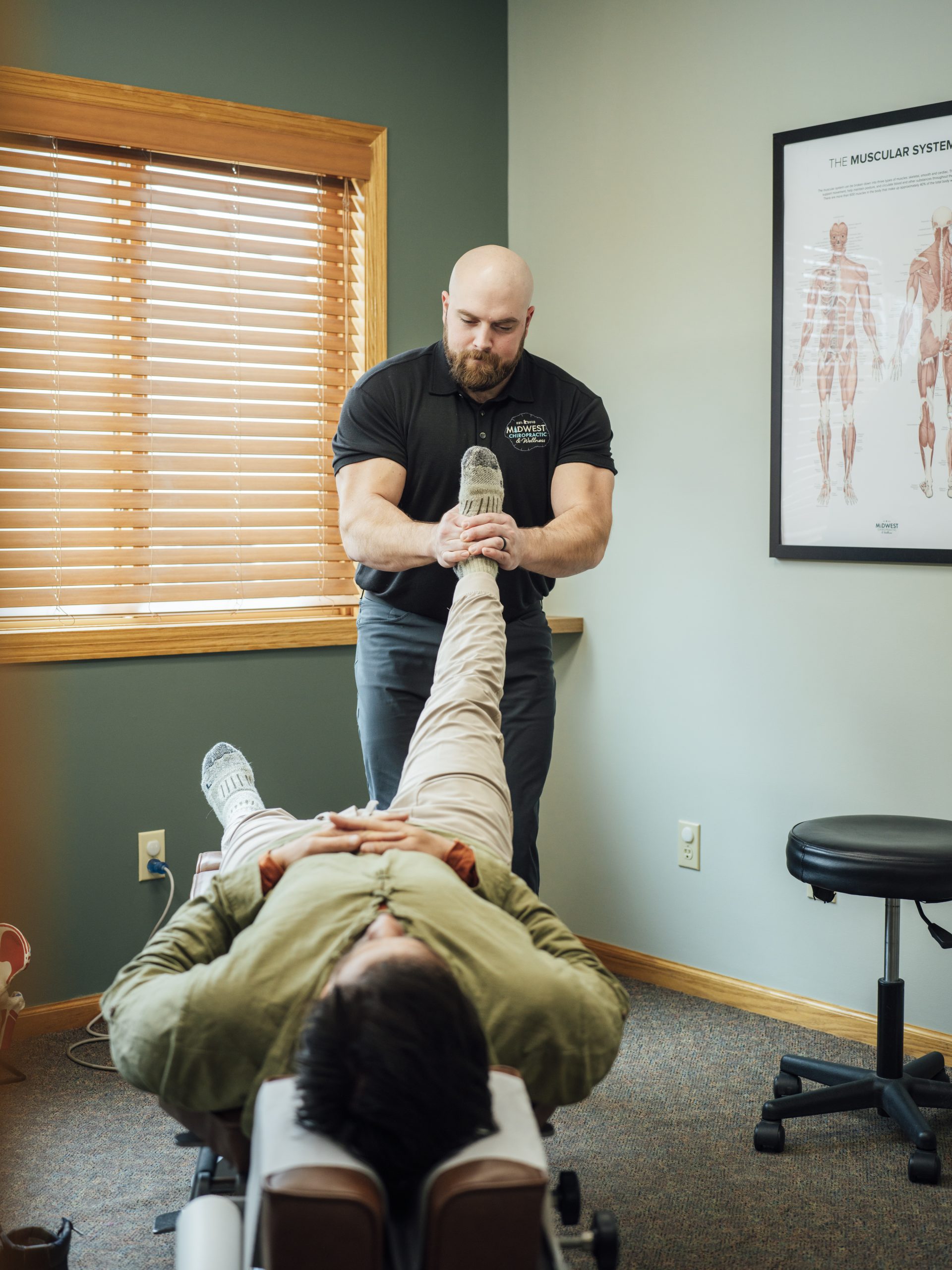 Dr. Mitch assessing a patient’s leg movement in the clinic.